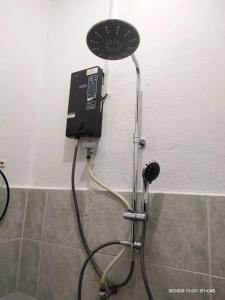 a shower in a bathroom with a phone on the wall at Bulat Cottage in Pantai Cenang