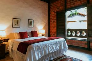 a bedroom with a bed and a brick wall at Pousada Pedra Azul in Pedra Azul