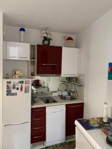 a kitchen with white cabinets and a white refrigerator at Cannes 3 min from Congress Palace, Croisette, Beaches in Cannes