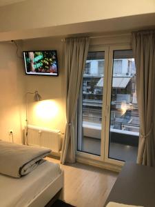 a bedroom with a bed and a tv on the wall at kolonaki Penthouse panoramic Acropolis view in Athens