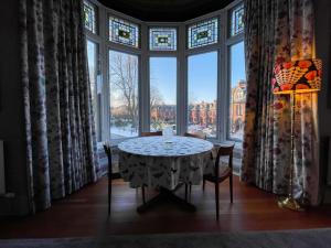 a table in a room with a large window at 1 Bed Character Filled Glasgow Apartment in Glasgow