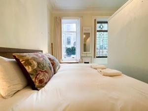- une chambre avec un grand lit blanc et une fenêtre dans l'établissement 1 Bed Character Filled Glasgow Apartment, à Glasgow