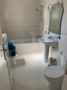 a bathroom with a toilet and a sink and a tub at Casa Estrella in Mojácar