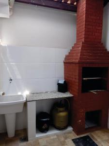 a bathroom with a sink and a brick oven at Uma PAUSA na sua vida, com: sol, praia e sossego! in Cabo Frio