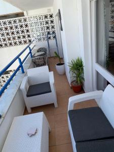 a balcony with white chairs and a table at Casa Estrella in Mojácar +10 photos