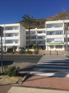 a large white building with a palm tree in front of it at Casa Estrella in Mojácar