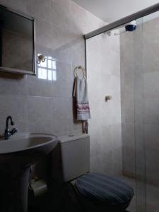 a bathroom with a toilet and a sink and a shower at Uma PAUSA na sua vida, com: sol, praia e sossego! in Cabo Frio
