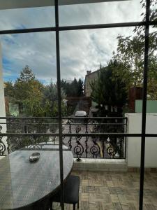 uma vista para uma varanda com uma mesa e um gato em Villa Mini Garden em Baku