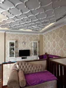 uma sala de estar com um sofá e uma televisão em Villa Mini Garden em Baku