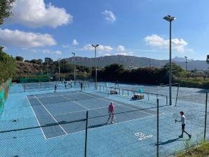 a group of people playing tennis on a tennis court at Appartements Modernes Vue Mer à Cap Estérel in Saint-Raphaël