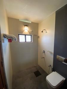 een badkamer met een toilet en een raam bij Pristine Hills in Meppādi