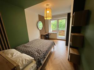 - une petite chambre avec un lit et une fenêtre dans l'établissement Apartament Partykularz z tarasem i widokiem na Śnieżkę, à Karpacz