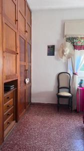 a room with a chair and a cabinet and a window at Casa con vista a la salida del sol in La Cumbre