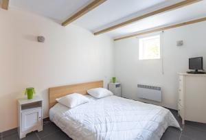 - une chambre blanche avec un lit et une télévision dans l'établissement Villa SAVANE, à Arcachon