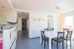 Il comprend une cuisine et une salle à manger avec une table et des chaises blanches. dans l'établissement Villa SAVANE, à Arcachon