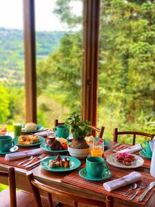 una mesa con platos de comida en ella con una ventana en Reserva da Collina, en Gramado