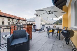 eine Terrasse mit einem Tisch, Stühlen und einem Sonnenschirm in der Unterkunft [Bellinzona] Rustico Loft a 5 Stelle con Netflix in Bellinzona