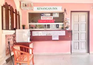 a restaurant with a wooden chair in front of a counter at Kenangan Inn in Pantai Cenang