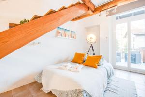 ein Schlafzimmer mit einem Bett mit orangefarbenen Kissen in der Unterkunft [Bellinzona] Rustico Loft a 5 Stelle con Netflix in Bellinzona