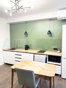 eine Küche mit einem Tisch und einer grünen Wand in der Unterkunft Apartment on KShT in Öskemen
