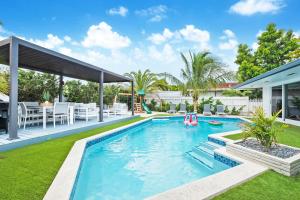 a swimming pool in a backyard with a pool toy at 5BR Oasis Heated Pool, Games L06 in Miami