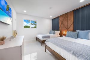 a bedroom with two beds and a desk at Stunning 5BR Heated Pool, Beach Access & Games L06 in Miami +26 photos