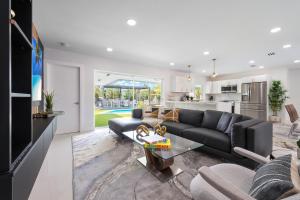 a living room with a black couch and a kitchen at 5BR Oasis Heated Pool, Games L06 in Miami