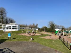an outdoor park with a playground and swings at Idyllic Entire Chalet in Bideford Bay holiday Park near Clovelly in Bideford