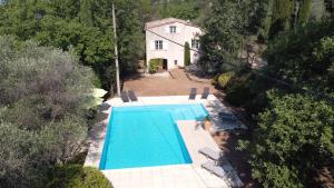 eine Aussicht auf einen Pool vor einem Haus in der Unterkunft Villa Frédérick (app. 5 personnes) in Bagnols-en-Forêt