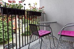 two chairs and a table on a balcony with flowers at Gdansk Old Town 2 room Apartment in Gdańsk