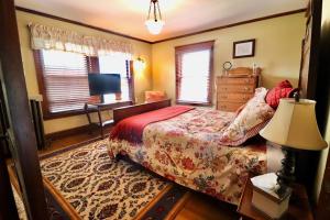 - une chambre avec un lit, un bureau et des fenêtres dans l'établissement The Marshall House, à Niagara Falls