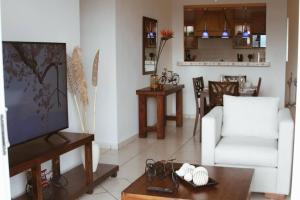salon z białą kanapą i telewizorem w obiekcie Lovely 3Brm Apt w/City View&Pool @heart of Escalon w mieście San Salvador
