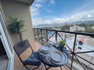 stół i krzesła na balkonie z widokiem w obiekcie Lovely 3Brm Apt w/City View&Pool @heart of Escalon w mieście San Salvador