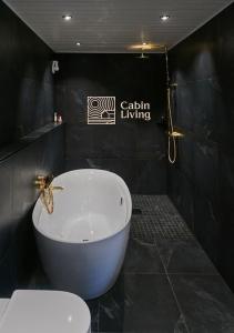 La salle de bains est pourvue d'une baignoire et de toilettes. dans l'établissement Grand cabin Nesfjellet lovely view Jacuzzi sauna, à Nes i Ådal