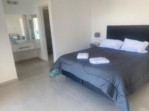 a bedroom with a large bed with two towels on it at AIRES DEL LAGO, Los Molinos 2 in Potrero de Garay +19 photos