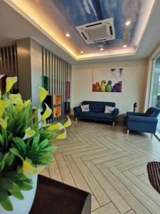 a living room with a blue couch and a living room with flowers at CAPITAL EXPRESS in Kota Kinabalu