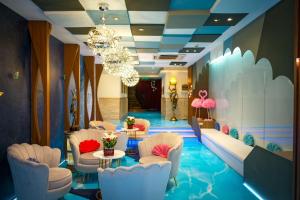 hol z krzesłami, stołami i żyrandolem w obiekcie Hotel Mermaid Bangkok w mieście Bangkok