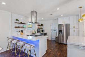 a kitchen with white cabinets and a counter with stools at The Desert Xscape Pool & Views in Palm Springs