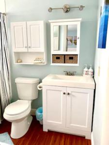 La salle de bains est pourvue de toilettes blanches et d'un lavabo. dans l'établissement Cozy Canaveral Beach Condo! Next to NASA Launch Site, à Cap Carnaveral