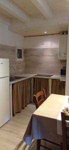 uma cozinha com uma mesa e um frigorífico branco em Villa Natura appartamento Open Space con giardino em Trento