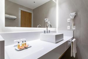 a white bathroom with a sink and a mirror at Mar Ipanema Hotel in Rio de Janeiro