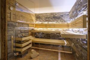 a glass shower in a room with a stone wall at Haus Bergheimat in Oberstdorf