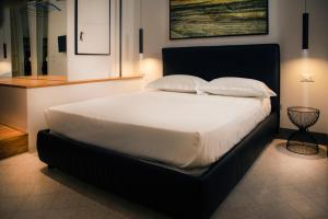 - une chambre dotée d'un grand lit avec des draps et des oreillers blancs dans l'établissement Nostrale bnb, à Palerme