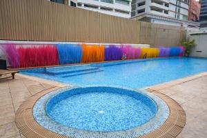 een groot zwembad in een gebouw met kleurrijke muren bij Hotel Mermaid Bangkok in Bangkok