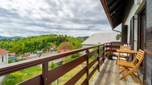 a balcony with chairs and a table on a house at apartman NOA in Fužine