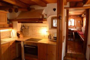 uma cozinha com armários de madeira e um forno com placa de fogão em Beim Dokterer, Fewo ANNO DAZUMAL em Halblech