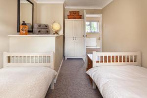 a bedroom with two beds and a mirror at Heron Cottage - Norfolk Cottage Agency in Castle Acre