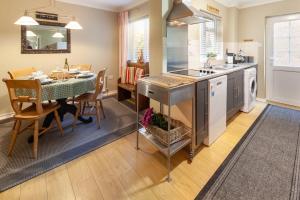 a kitchen and dining room with a table and a dining room at Heron Cottage - Norfolk Cottage Agency in Castle Acre