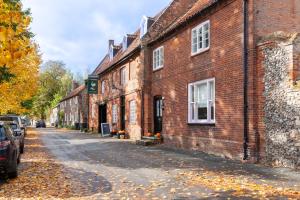 an empty street in front of a brick building at Heron Cottage - Norfolk Cottage Agency in Castle Acre