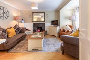 a living room with two couches and a fireplace at Heron Cottage - Norfolk Cottage Agency in Castle Acre